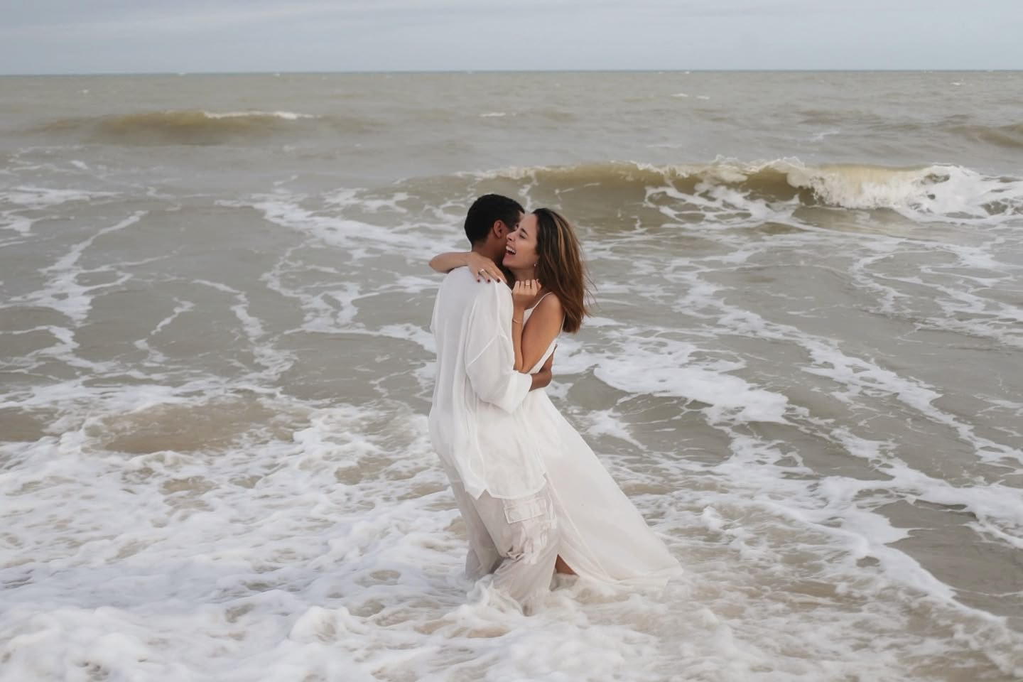 Carla e João abraçados no mar